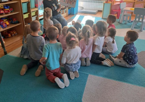 Mama czyta książeczkę i pokazuje ilustracje dzieciom