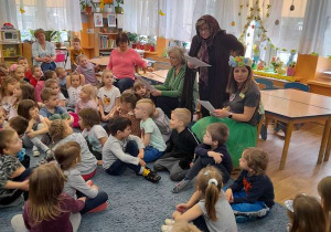 Baba Saba czyta dzieciom swoją rolę.