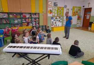 Dzieci na dywanie rozmawiają z Panem Miłoszem.