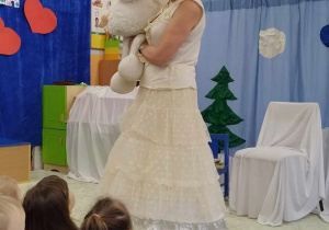 Dzieci siedzą na dywanie, aktorka wciela się w rolę bałwanka