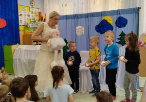 Dzieci oglądają kule i lalkę trzymaną przez aktorkę