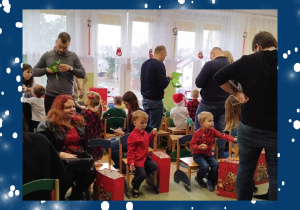 Dzieci i rodzice oglądają prezenty od Świętego Mikołaja.
