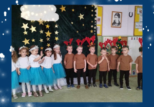 Grupa dzieci w świątecznych przebraniach podczas występu świątecznego.