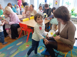 Dzieci wręczają kwiatki swoim mamom.