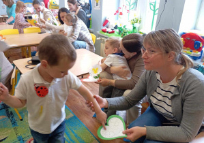 Chłopiec wręcza swojej mamie papierowe serduszko