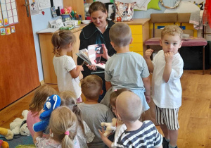 Adwokatka (ubrana w togę) czyta dzieciom książkę.