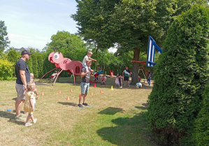 Tata i chłopiec celują piłka do kosza.