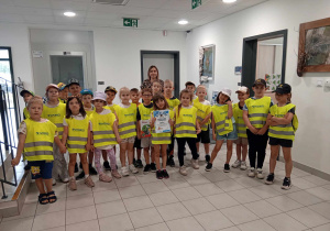 Dzieci stoją w Urzędzie Miejskim z dyplomem i nagrodą.