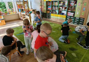 Dzieci biorą udział w zabawie polegającej na zbieraniu piłeczek na czas.