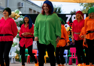 Nauczyciele i pracownicy przedszkola na scenie w strojach krasnoludków.