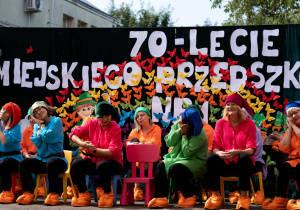 Nauczyciele i pracownicy przedszkola na scenie w strojach krasnoludków.