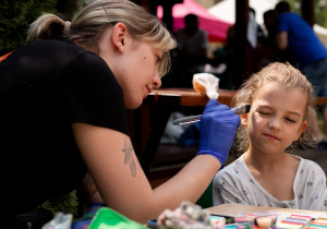 Dziecko w trakcie wykonywania "makijażu" przez animatorkę.