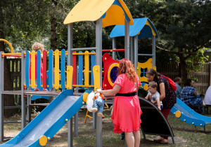 Dzieci bawiące się na zabawkach ogrodowych.