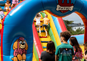 Dzieci bawiące się na dmuchanym zamku.