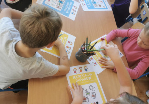 Dzieci wykonują zadania związane z segregacją odpadów.
