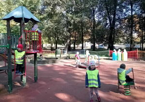Dzieci na placu zabaw bawią się w słonecznych promieniach jesieni.