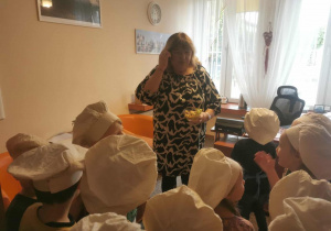 Grupa dzieci częstuje wykonana przez siebie sałatką panią dyrektor.
