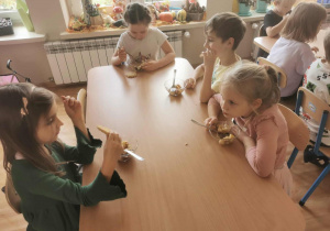 Grupa dzieci je wykonaną przez siebie sałatkę owocową.