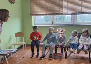Pani bibliotekarka słucha wypowiedzi chłopca.