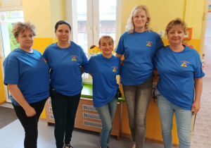 Grupa pań w niebieskich podkoszulkach.