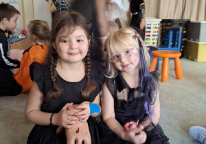 Dwie dziewczynki w halloweenowych strojach.