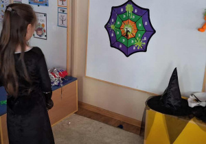 Dziewczynka celuje klejącym pająkiem do kolorowej tarczy.