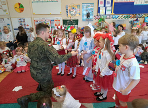 Żołnierz wręcza dzieciom nagrody za udział w konkursie.