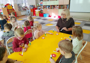 Pani Naczelnik wraz z dziećmi wykonują kokardy narodowe.