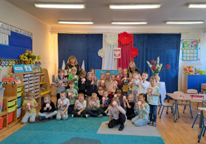 Dzieci wraz z panem Burmistrzem prezentują wykonane przez siebie kokardy narodowe.