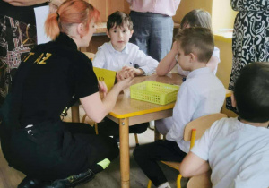 Dzieci siedzące przy stoliku udzielają odpowiedzi na zadane przez jury pytanie.