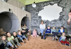 Dzieci z uwaga słuchają czytanej książki.