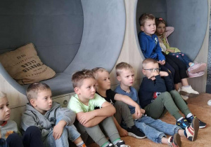 Dzieci z uwaga słuchają czytanej książki.