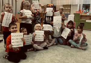 Dzieci wykonują zadania na kartach pracy- zróżnicowane zależnie od wieku.