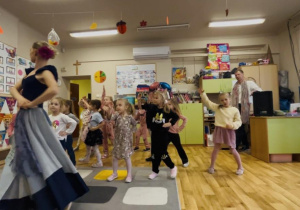 Grupa dziewczynek podczas tańca wg. instrukcji tancerki baletowej.