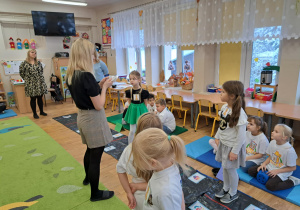 Nauczycielka czyta zagadkę dzieciom.