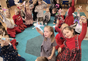 Dzieci prezentują wykonane kukiełki z papieru.