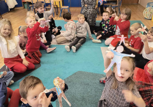 Dzieci prezentują wykonane kukiełki z papieru.