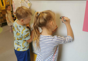 Dzieci malują mazakami na tablicy