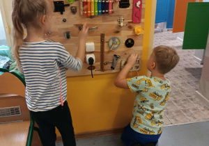 Dzieci manipulują na tablicy sensorycznej