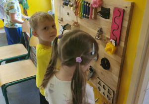 Dzieci manipulują na tablicy sensorycznej