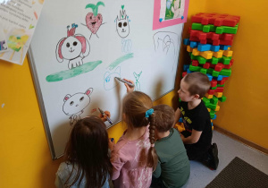 Przedszkolaki rysują na tablicy według własnego pomysłu
