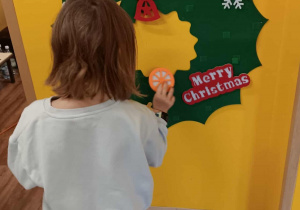 Dziewczynka ozdabia wieniec bożonarodzeniowy