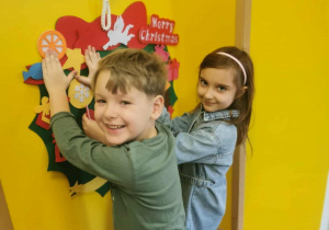 Dzieci ozdabiają wieniec bożonarodzeniowy