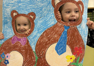 Dzieci pozują do zdjęcia w fotobudce.