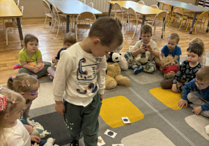 Dziecko dopasowuje figurę geometryczną do kształtu buzi misia.