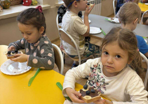 Dzieci jedzą zrobione przez siebie kanapki.