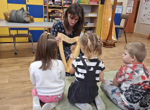 Harfistka prezentuje dzieciom instrument.