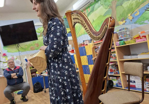 Harfistka prezentuje swój instrument.