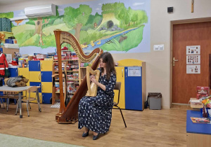 Harfistka gra na harfie.