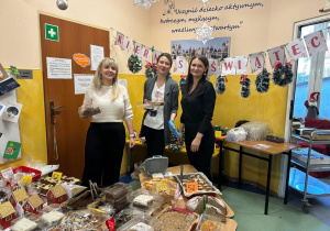 Trzy mamy podczas kiermaszu świątecznego w przedszkolu.